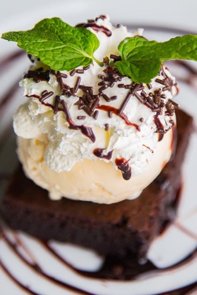 Helado con nata, virutas de chocolate y hojas.